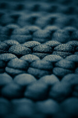 Dark blue grey background massive knitted thread pattern closeup