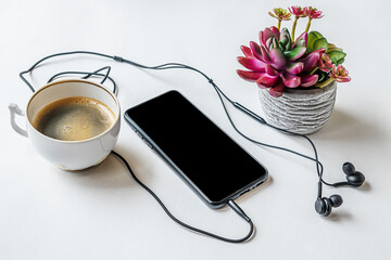 cup of coffee, smartphone, headphones and succulent plant in a pot on a white surface, mock up, isolated black screen - Powered by Adobe