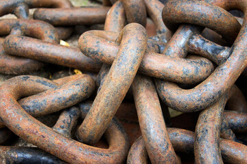 Heavy metallic randomly arranged messy chain with orange rust.