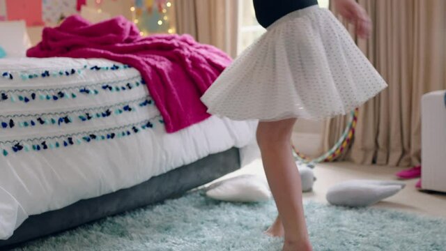 happy teenage girl dancing in bedroom wearing ballet tutu having fun practicing dance moves at home