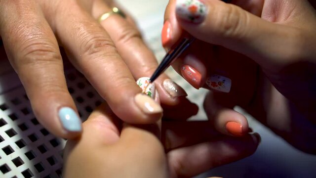 Manicure procedure. Applying nail polish in nail salons. Concept of beauty treatment, femininity, fashion and beauty products.
