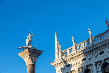 Fototapeta na wymiar Sculpture of Sacred Teodor - the first patron of Venice standing on a dragon won by it. It is established at column top on Piazza San Marco, Venice