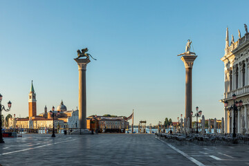 Fototapeta na wymiar early morning view with rising sun to pillar with lion and dragon fighter at St. Mark's square in Venice