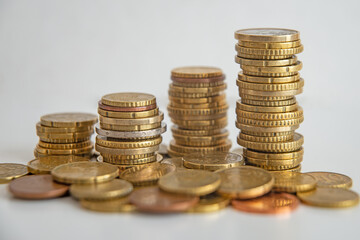 Stacks of euro coins placed on white surface. Money and value of money.
