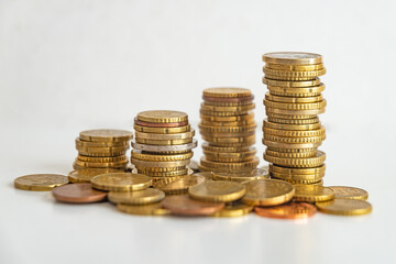 Stacks of euro coins placed on white surface. Money and value of money.
