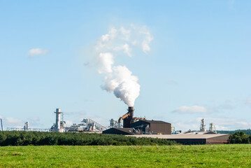 Fototapeta na wymiar Biomass heat plant in Europe emitting white smoke.