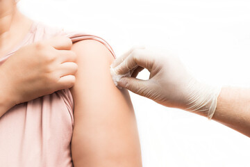 doctor cleaning the arm area where he is going to inject the patient