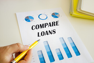 Financial concept meaning COMPARE LOANS with phrase on the financial document.