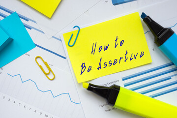 Financial concept meaning How to Be Assertive with phrase on the sheet.