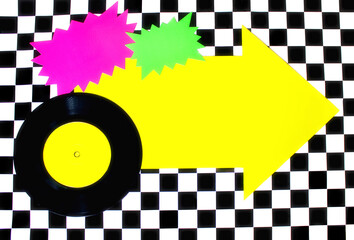 Photograph of 45rpm record with colorful shapes on Checkered floor