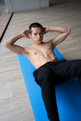 Obraz premium Sport man doing abs crunches exercise, fitness workout on a blue mat