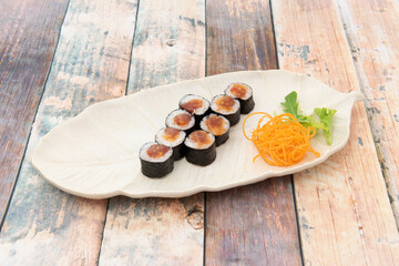 tray with portion of red tuna maki with white rice, sauce and nori seaweed