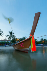 Thai long tail boat moored at the shore of a beach in Phuket