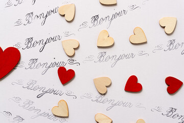 rubber stamp background with the french word bonjour with red and plain wood hearts © eugen
