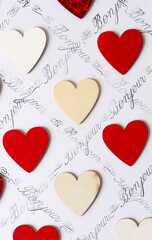 wooden hearts - some hand painted red - on a white background with the french expression "bonjour" © eugen
