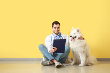 Veterinarian with cute dog on color background