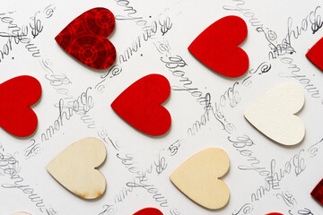 wooden hearts - some hand painted red - on a white background with the french expression "bonjour" © eugen