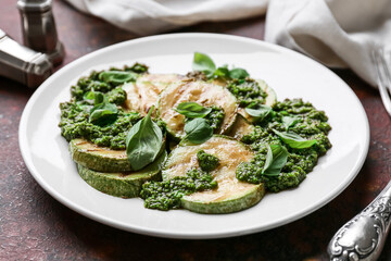 Plate with tasty grilled squash and pesto sauce on color background, closeup
