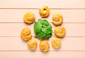 Puff pastry stuffed with spinach on color wooden background
