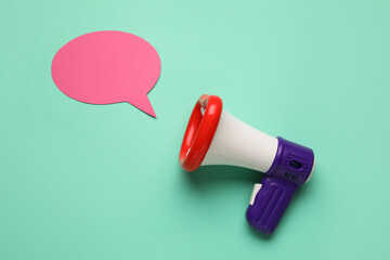 Toy megaphone and speech bubble on color background