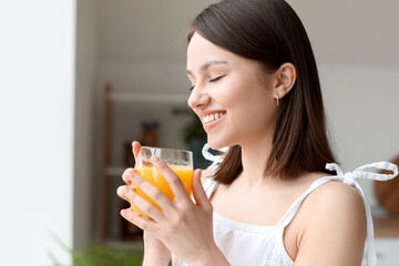 Young woman with glass of juice at home