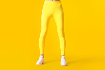 Legs of sporty young woman in leggings on color background - obrazy, fototapety, plakaty