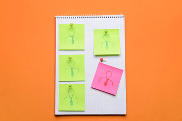 Notebook and paper notes with drawn workers on color background. Concept of dismissal