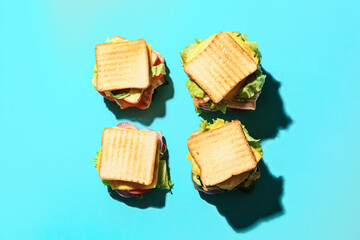 Tasty sandwiches on color background