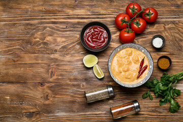 Bowl of tasty chicken curry and ingredients on wooden background