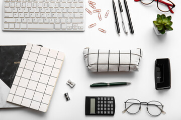 Composition with stationery, keyboard and pencil case on white background, closeup