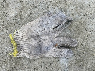 Close up old fabric glove on cement floor