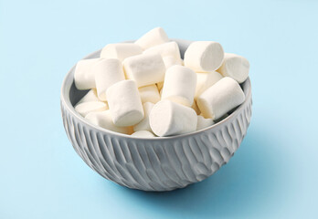 Bowl with tasty marshmallows on color background, closeup