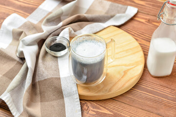 Glass cup of tasty Charcoal Latte on wooden background