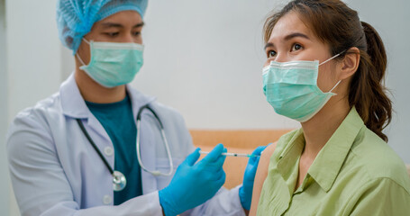 
Vaccination, immunization, disease prevention concept. Patient getting Covid-19 vaccine at doctor's office. Cropped shot of professional nurse in medical face mask giving flu injection to young woman
