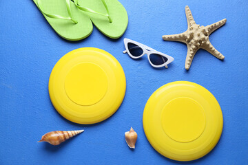 Composition with frisbee disks, sunglasses and flip-flops on color background