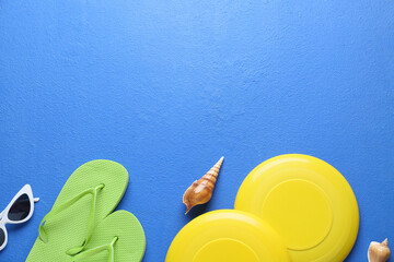 Frisbee disks, flip-flops and sunglasses on color background, closeup