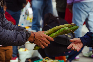detail of hands exchanging products in a market
