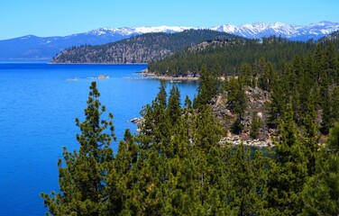 Landscape view of Lake Tahoe with snow-covered mountains and forests