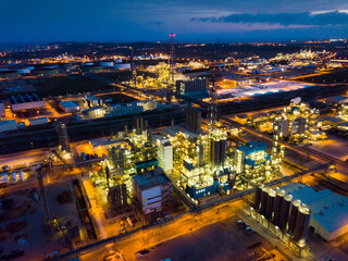 Fototapeta na wymiar Aerial view of illuminated chemical process plant near Spanish town of Salou at twilight