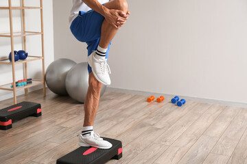 Naklejka premium Sporty young man training in gym