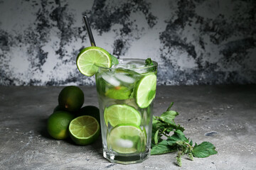 Glass of fresh mojito, limes and mint on grunge background