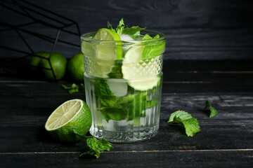 Glass of fresh mojito on dark wooden background