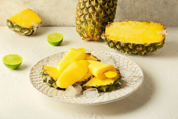 Plate with tasty pineapple popsicles on light background
