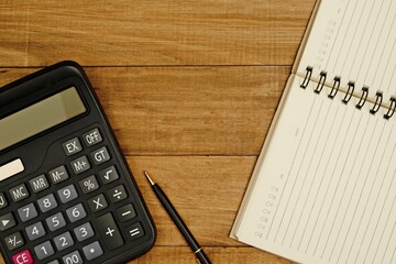 A calculator with a pen and notepad