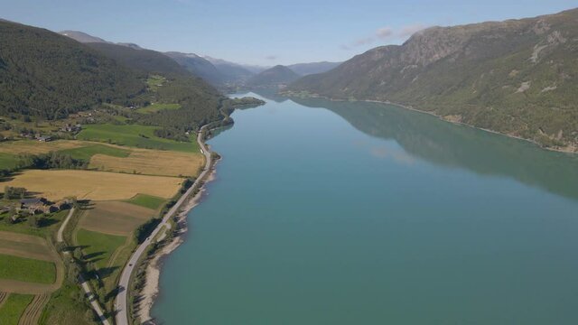 Aerial shot flying over a river snaking through a mountain valley in Norway