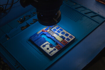 Primer plano de un microscopio para técnico trabajar en reparacion de teléfono móvil.