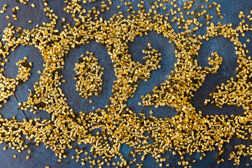 On a dark blue background, the numbers 2022 and gold confetti. Happy New Year 2022. Minimalism. Postcard, banner, poster. There are no people in the photo.