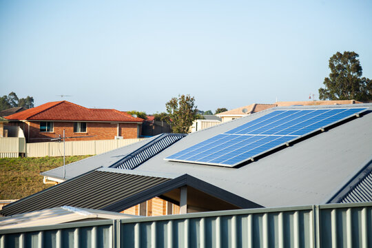Solar panels on home roof in town with blue sky copy space