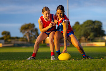 two female footballers going for the ball during training