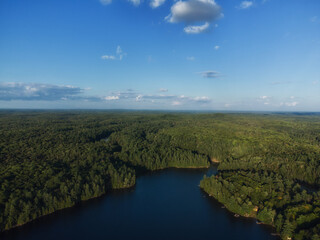 Buckskin Lake on a late summer afternoon. Aerial above the expansive evergreen wilderness of crown land in Tory Hill, Highlands East, Ontario, Canada. © Atomazul
